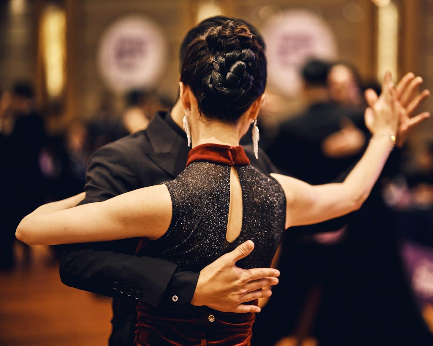 Two dancers in close embrace on a golden ballroom floor